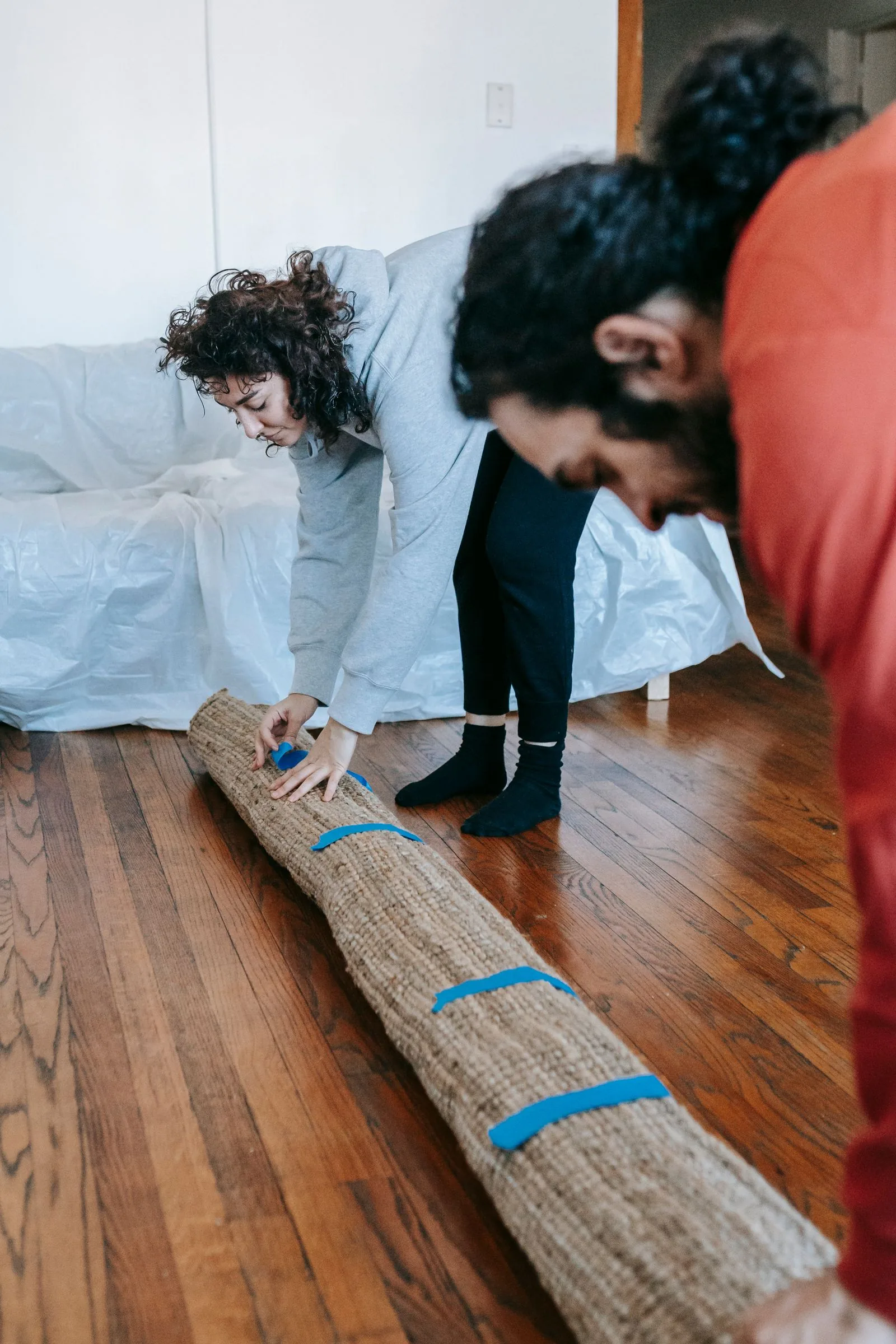 Couple rolling up a carpet during room cleanout