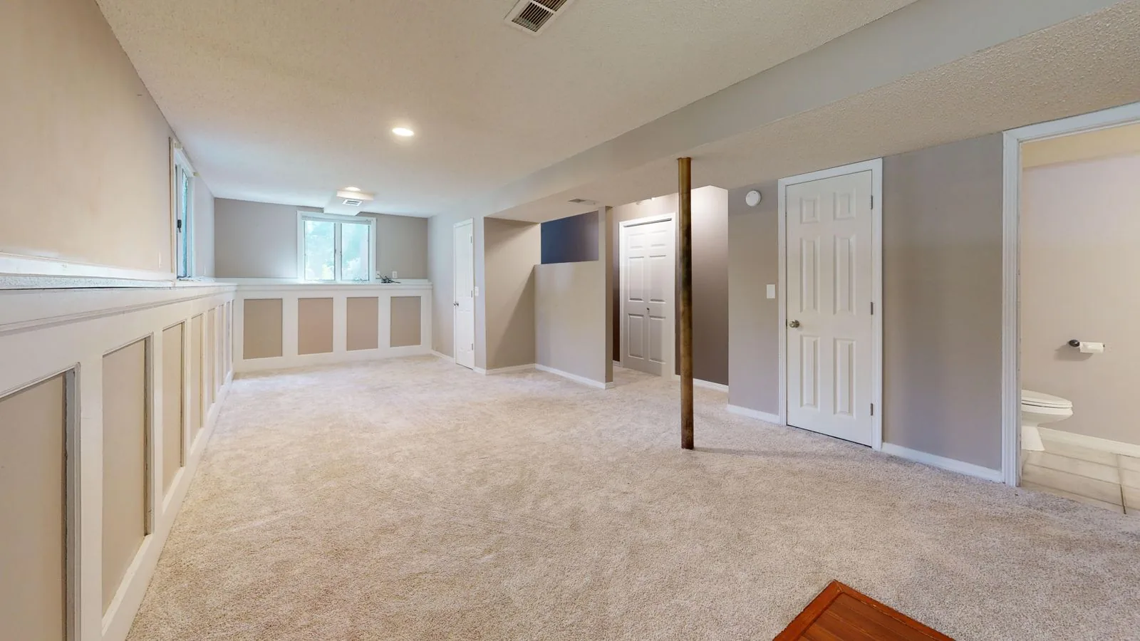 Bright, clean modern basement interior with recessed lighting