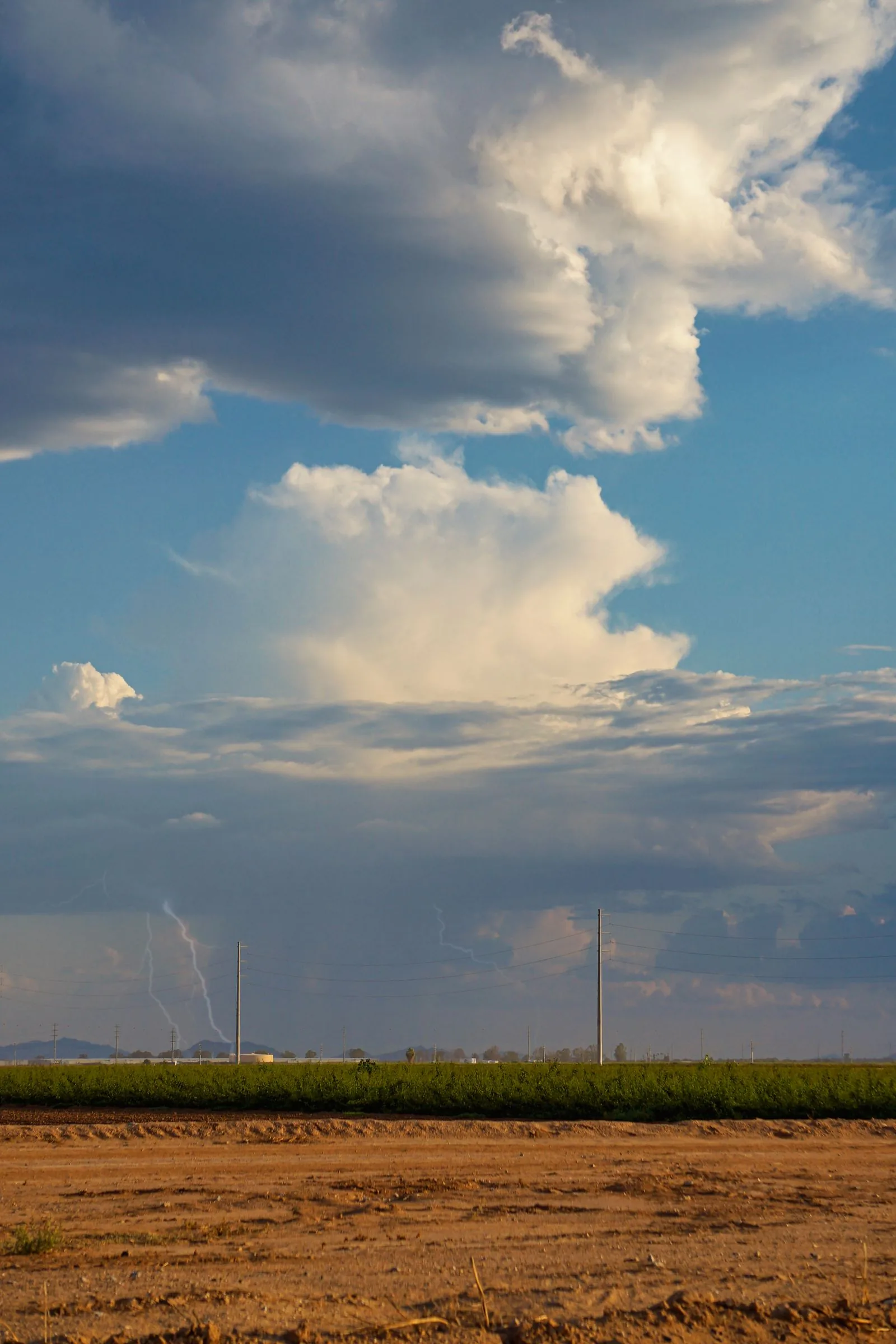 Lightning bolt over an Arizona countryside field under dramatic clouds