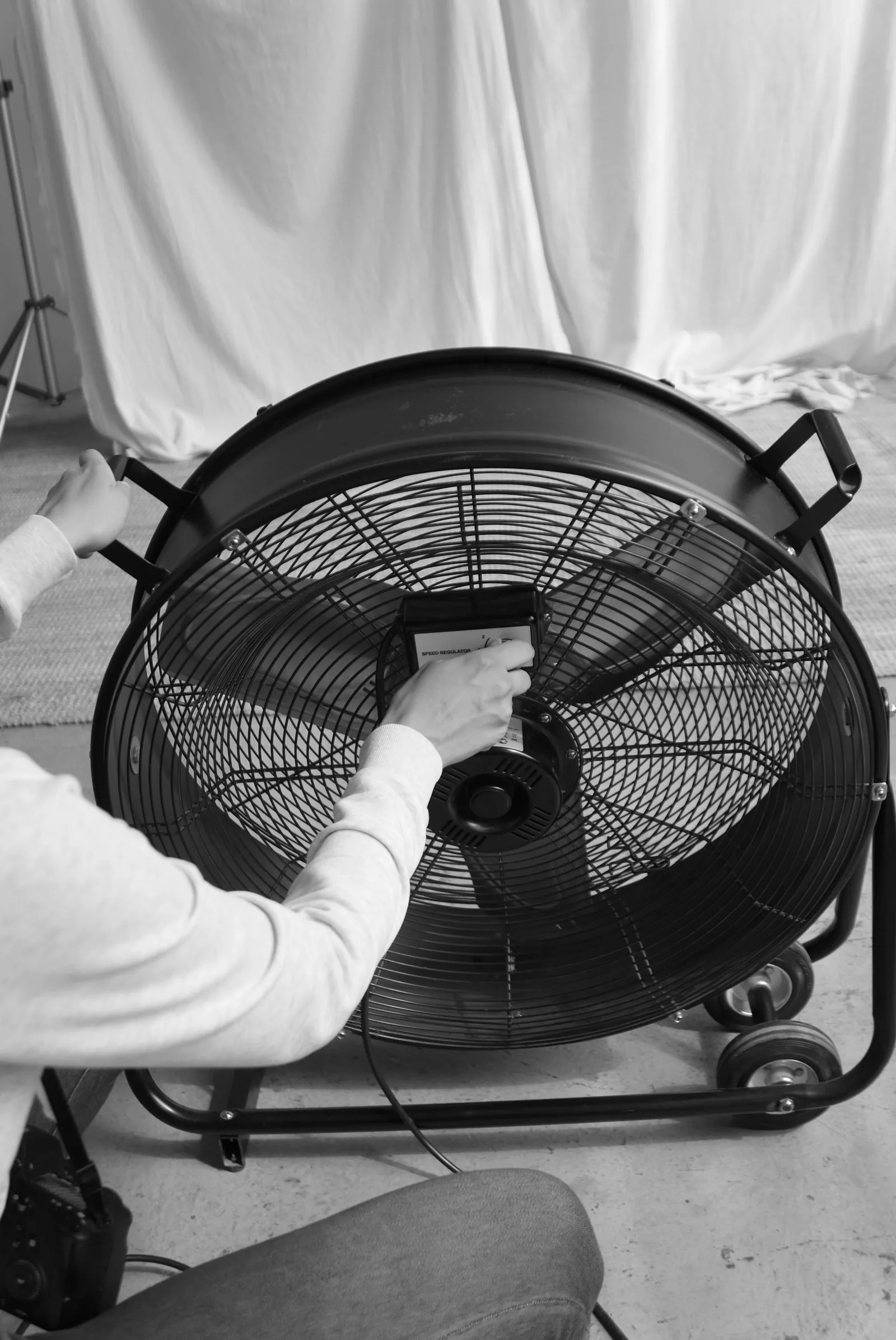 Worker adjusting an industrial fan indoors